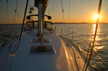 Fotobehang Zeilen Zeilboot vaart weg van zonsondergang  © Mark Rasmussen