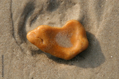 markanter stein in orange am strand photo