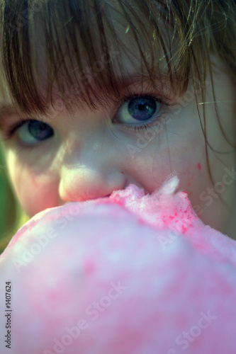 close up of young girl eating cotton candy