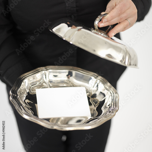woman showing a business card on a silver plate