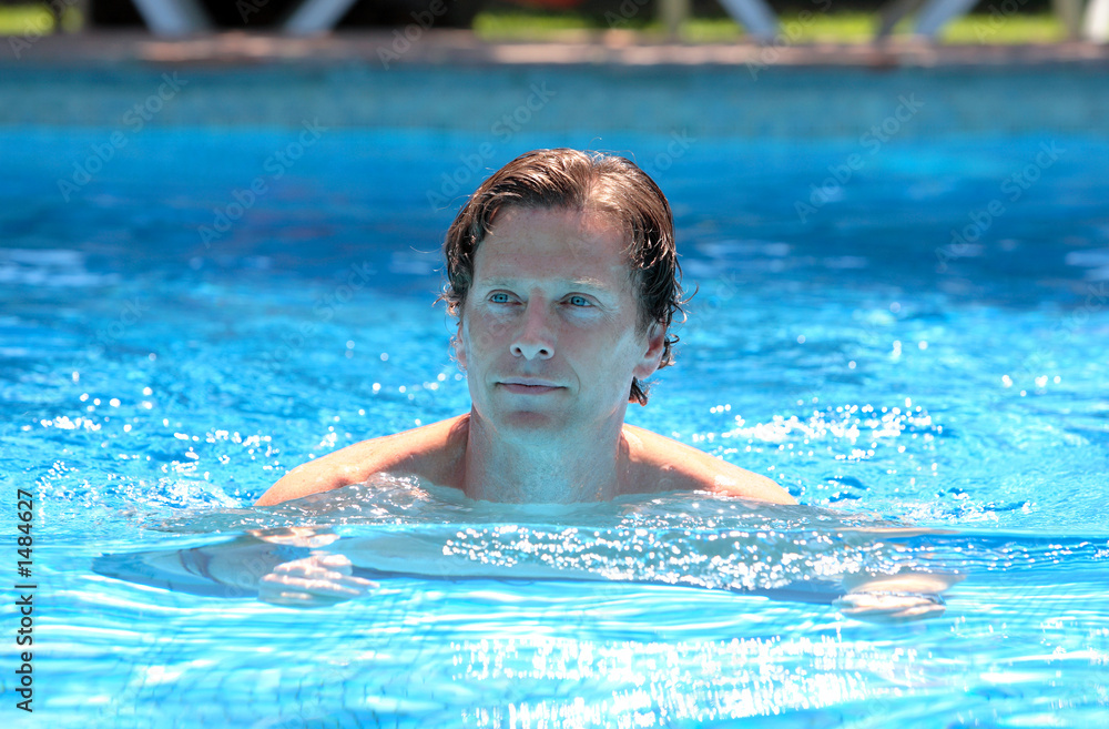 handsome middle aged man swimming in outdoor pool