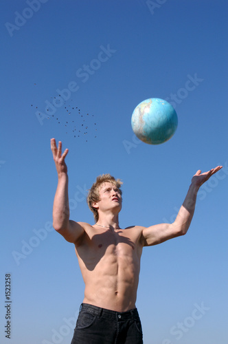 young muscular man playing with a globe