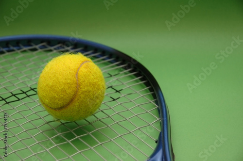 tennis ball and racket on green background