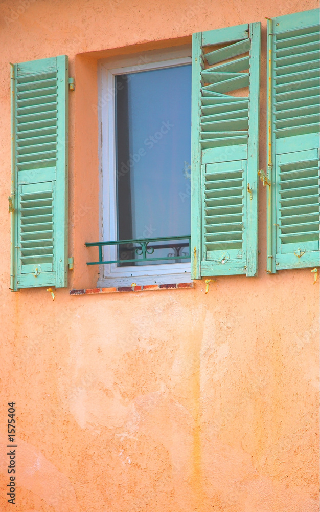 window with green damaged shutters in france