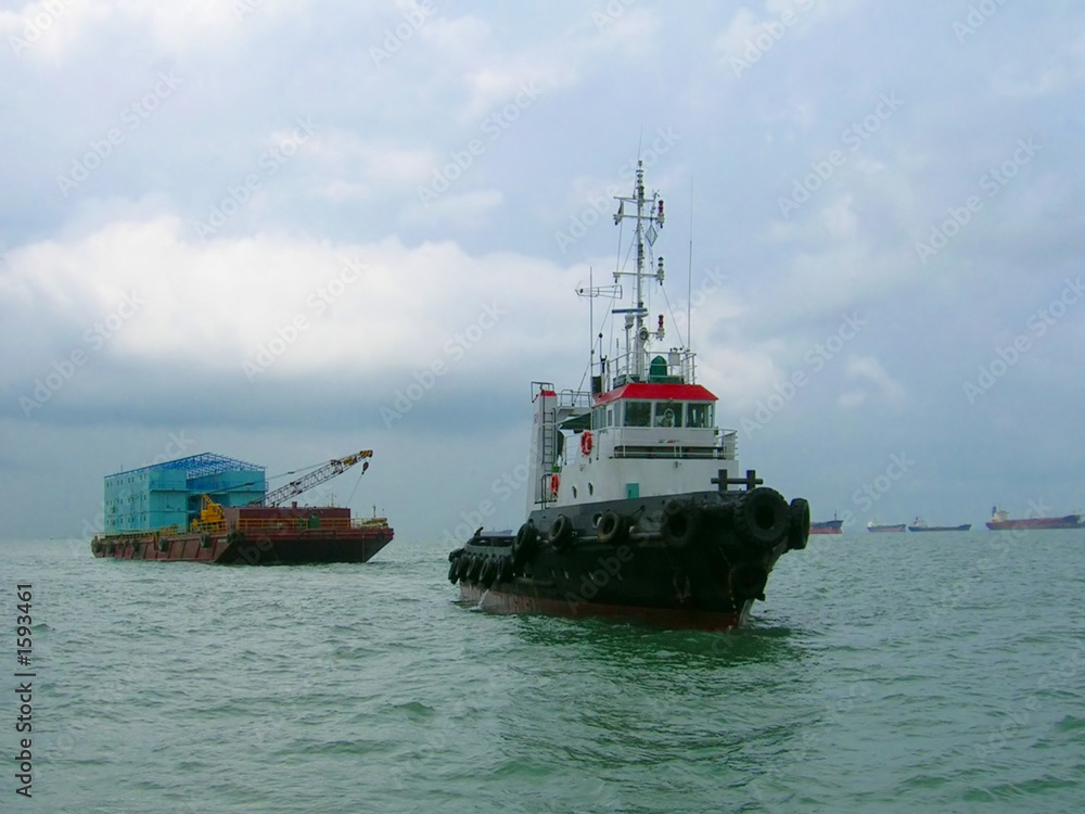 tug boat and barge in open sea
