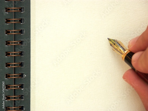 main et stylo écrivant sur une page blanche photo