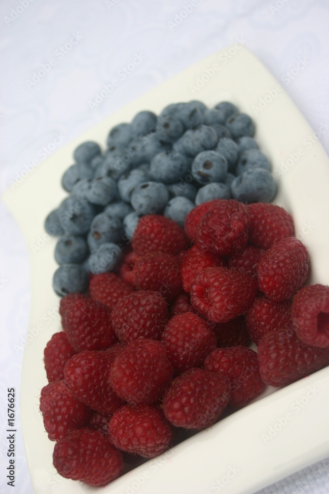 raspberries and blueberries on white plate raspberries and blueberries on white plate