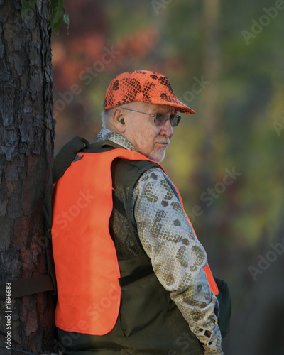 deer hunter leaning against tree