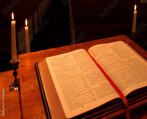 bible on pulpit in candlelight - angled view photo