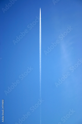 a jet flying overhead with jet trails.