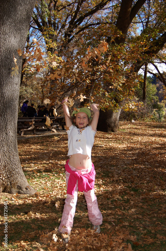 girl tossing leaves
