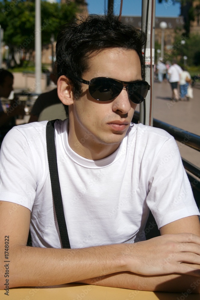 Fototapeta premium young man sitting with sun glasses