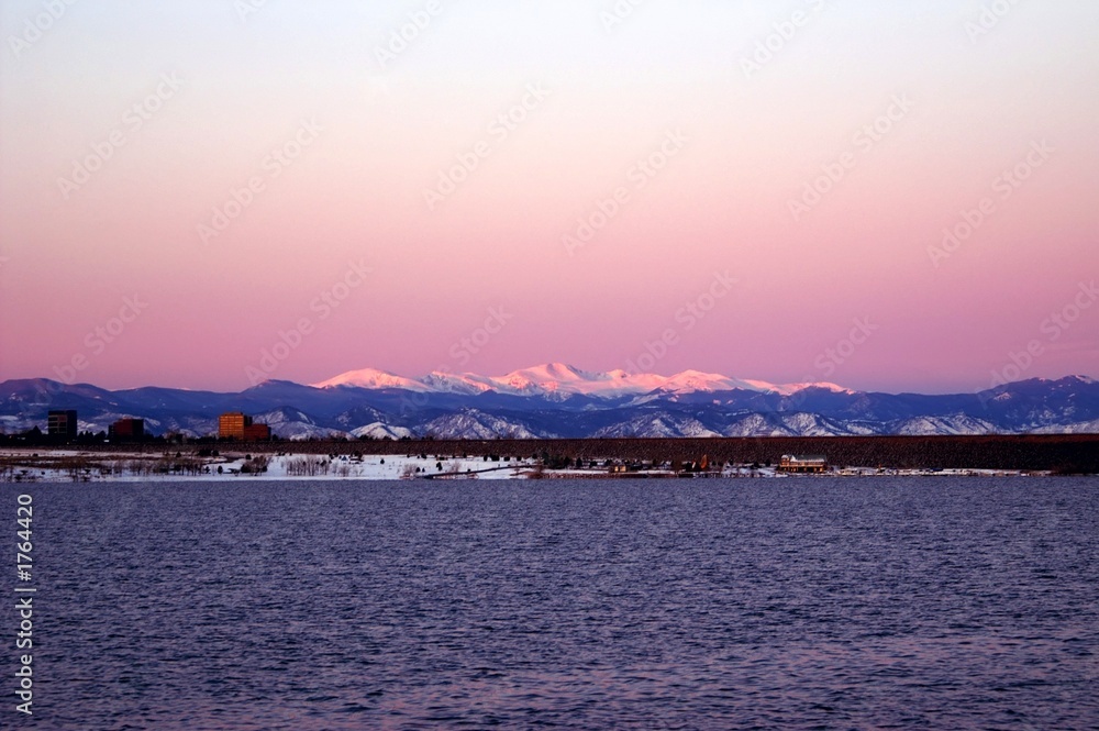 winter sunrise in denver with a lake and mountains