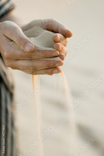 fine sand leaking through hands - sahara desert, v