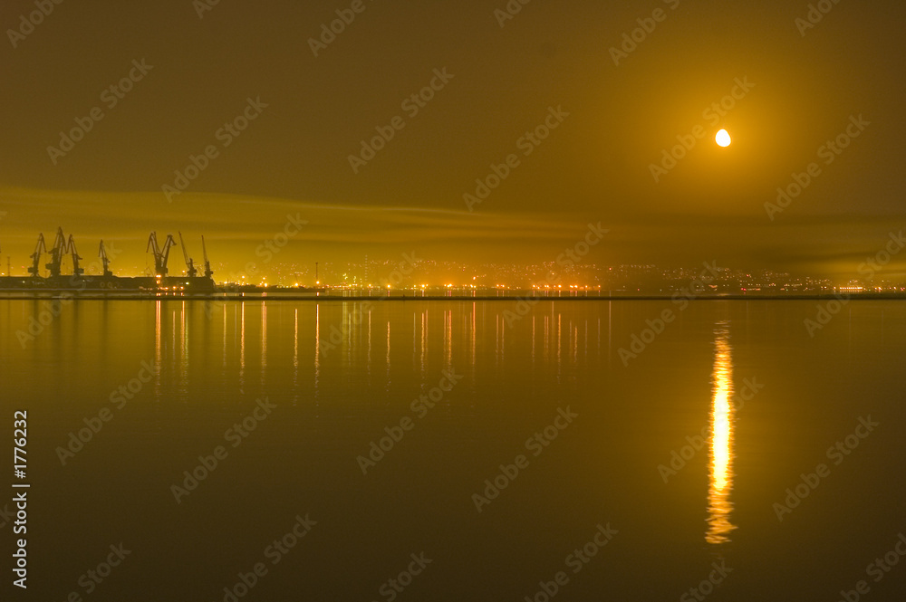 Obraz premium reflections of city and moon in the caspian sea -