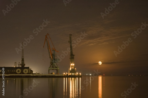 cranes in the port and reflection of moon in the w