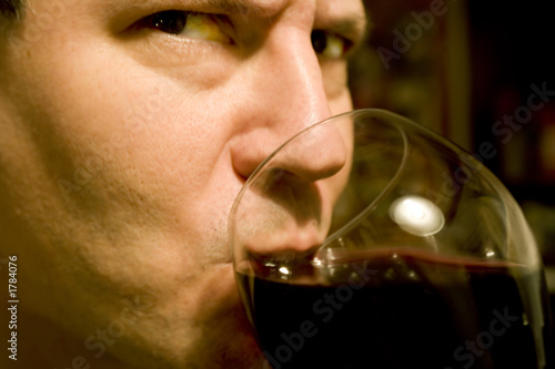 attractive, serious man drinking wine