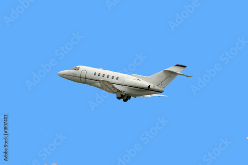 business jet taking off isolated over blue