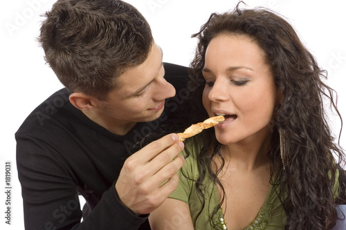 young couple feeding each other roll cake