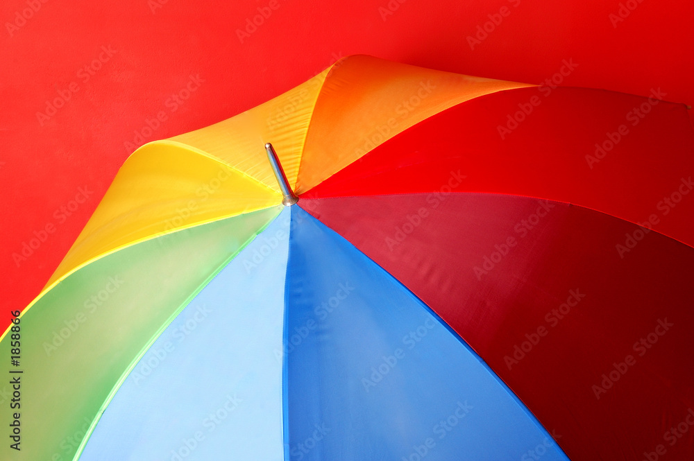 particoloured umbrella on red background