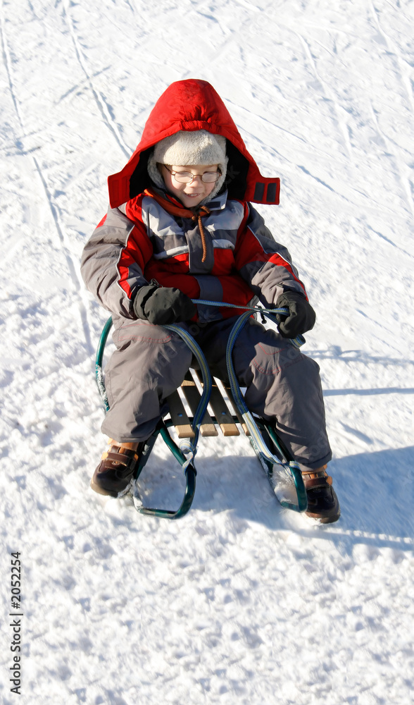 boy on sled in winter time