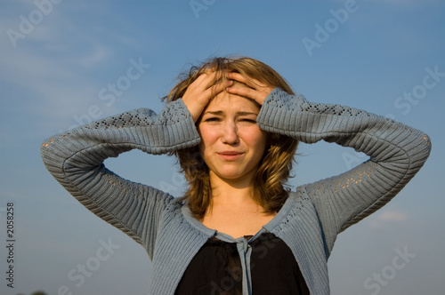 depressed young model holding her head crying