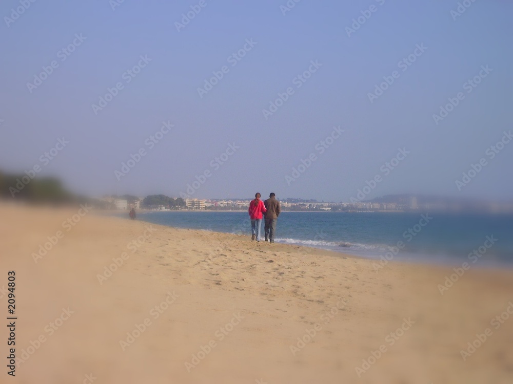 lovers arm in arm on deserted beach