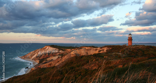 sunset over red cliffs and lighthouse photo