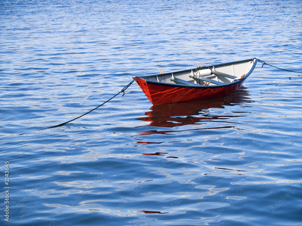 Naklejka premium small red boat in vivid water