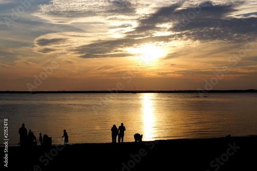 silhouette of family at sunset on beach