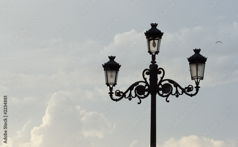 streetlamp against blue sky with clouds