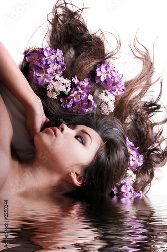 gorgeous long haired woman with flowers in water