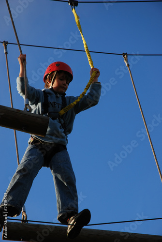 boy takes a risk by standing on a steel wire