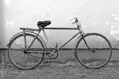 old bicycle leaning against a wall