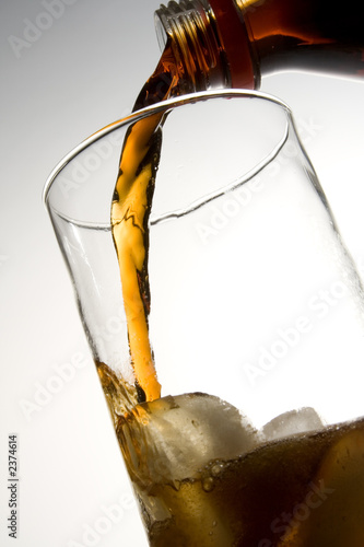 cola pouring into glass with ice photo