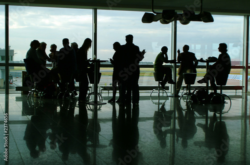 silhouettes in airport having coffee