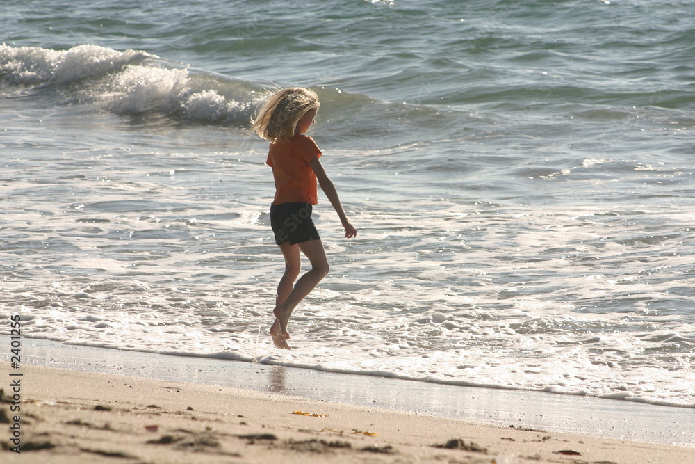 blonde girl in red playing in the ocean blonde girl in red playing in the ocean