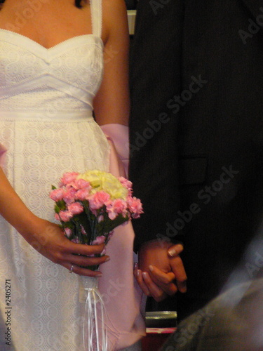 bride and groom holding hands, while bride holds b