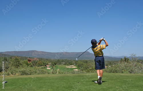 young golfer hitting a golf ball tee shot in the m