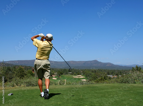 golfer driving golf ball on beautiful golf course
