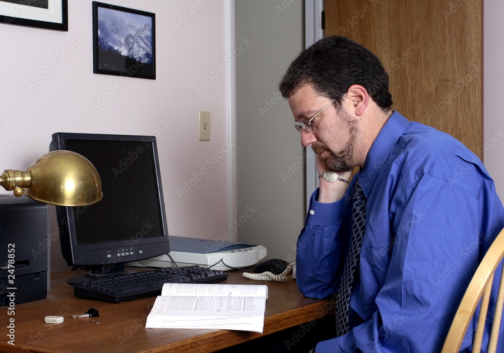 middle-aged man reading at the computer middle-aged man reading at the computer