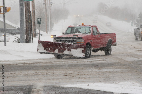 snow plow driving on snow covered street