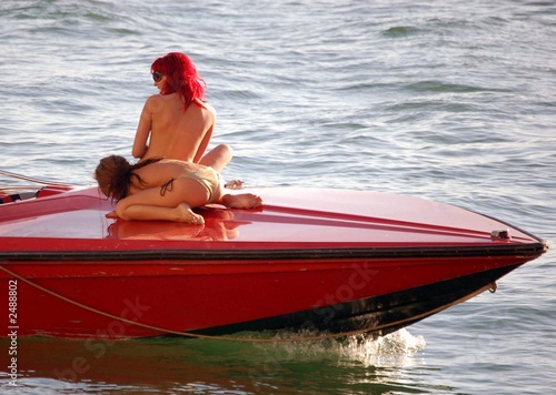 topless girls on the deck of a speed boat