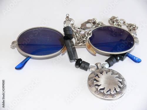 blue sunglasses with a necklace medallion