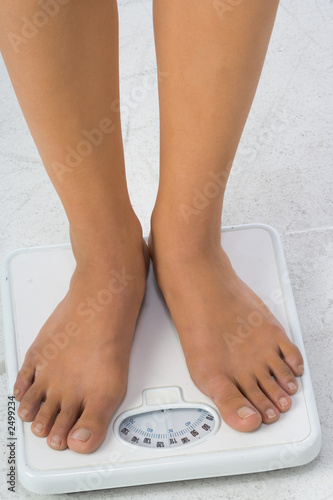 two female feet on a bathroom scale