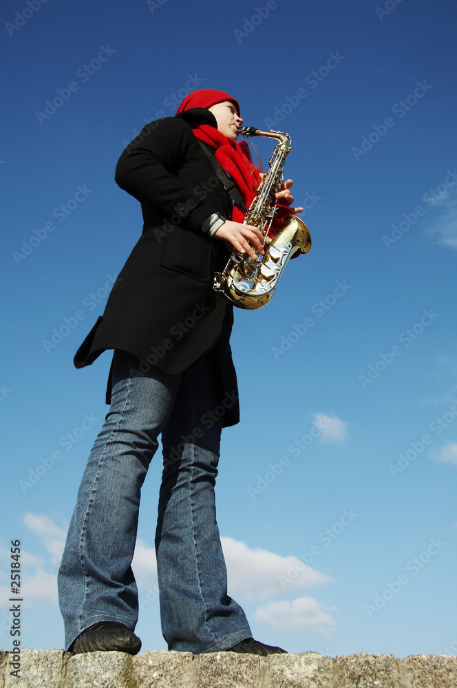 Naklejka premium girl plays on a saxophon
