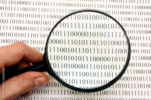 magnifying glass and binary code