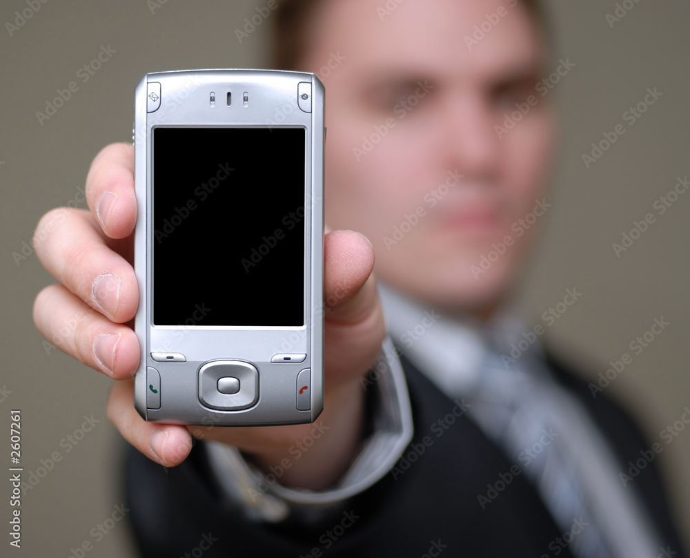 businessman shows cell phone with shallow depth of field