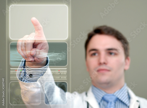 young doctor pressing glowing button on translucent medical disp photo