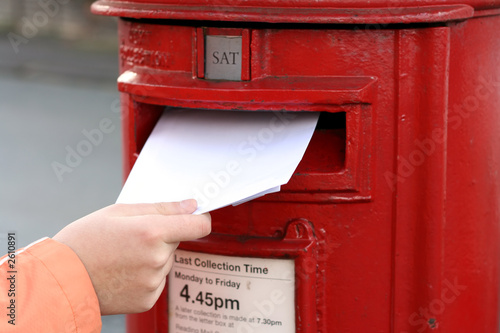 Photo posting letter to red british postbox